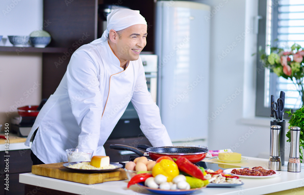 mature chef preparing a meal with various vegetables and meat mature chef preparing a meal with various vegetables and meat