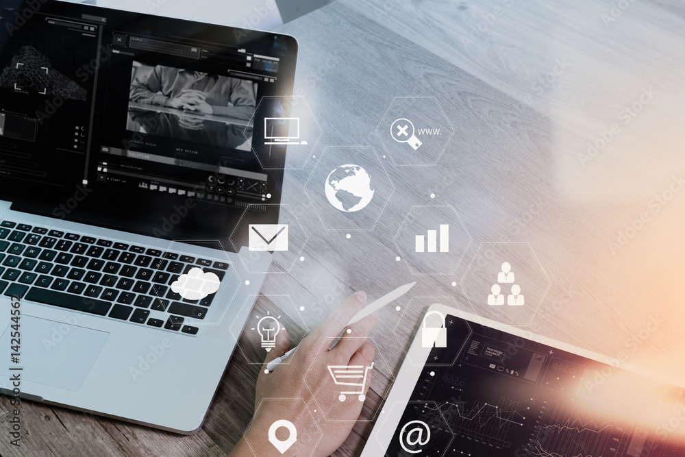 Fototapeta premium businessman working with smart phone and laptop computer on wooden desk in modern office with virtual icons interface