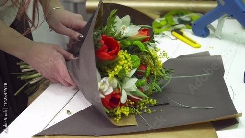 Florist wraps the bouquet in the flower wrapping paper