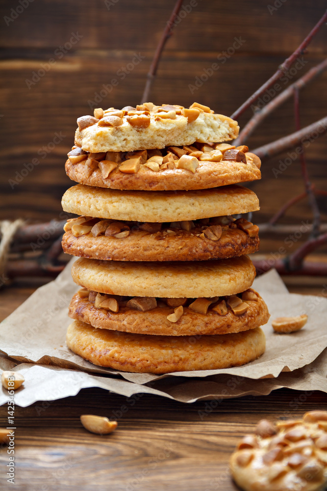 Cookies with a peanut on paper for pastries on wooden table. Selective focus, closeup. Cookies with a peanut on paper for pastries on wooden table. Selective focus, closeup.