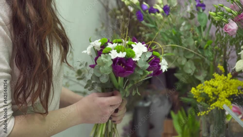 Florist adding some flowers to the bouquet closeup