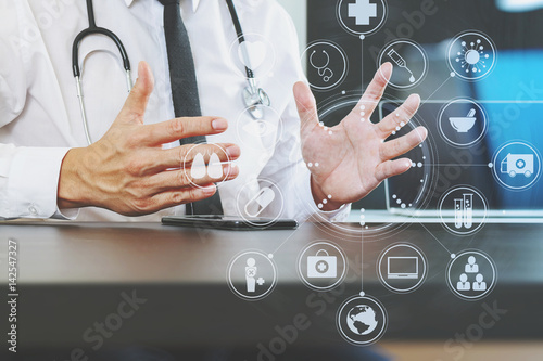 smart medical doctor working with smart phone and digital tablet computer and stethoscope on wood desk in modern office © everythingpossible