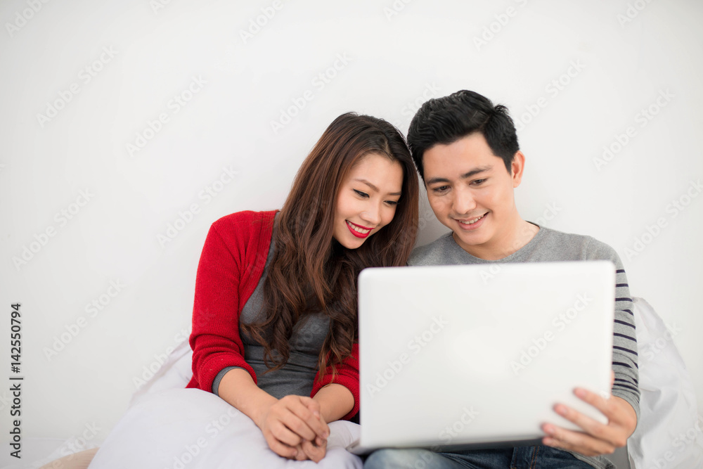 Asian couple lovers using laptop at home