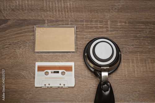 Retro audio tape and headphones on brown wooden background