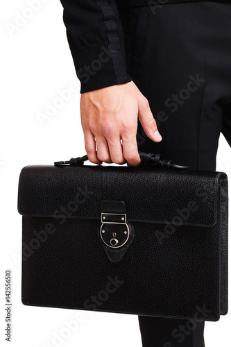 A man in a classic suit holds a black briefcase