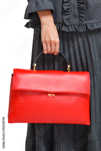 Girl holds a red bag close-up on an isolated white background