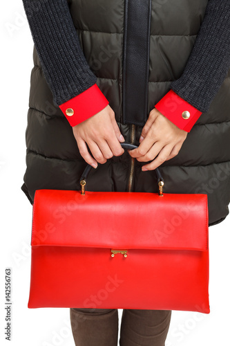 Girl holds a red bag close-up on an isolated white background