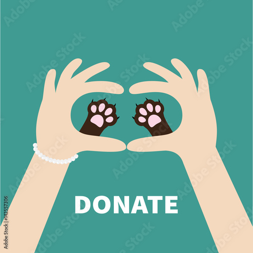 Two hands holding cute cat dog paw print. Love and care pet animals. Helping hand concept. Donate text. Flat design. Green background. Template.