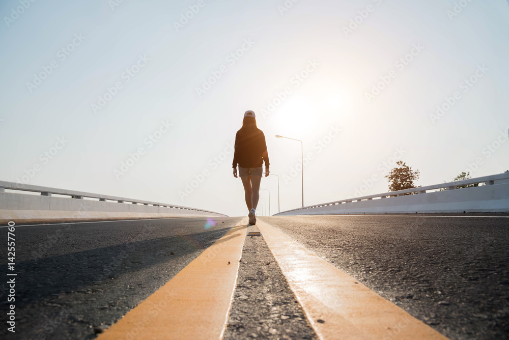 silhouette woman walking on street in the sunset. Stock Photo | Adobe Stock