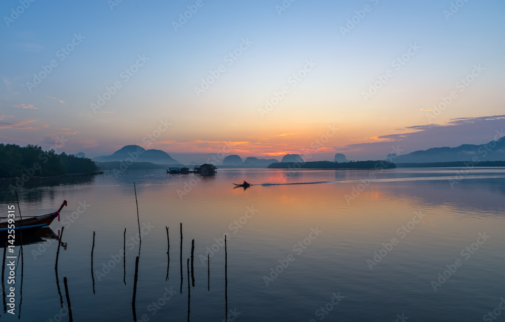 Beautiful sunrise landscape view of fisherman and wooden boat in early morming at Samchong-tai fishing village in Phang-Nga,Thailand