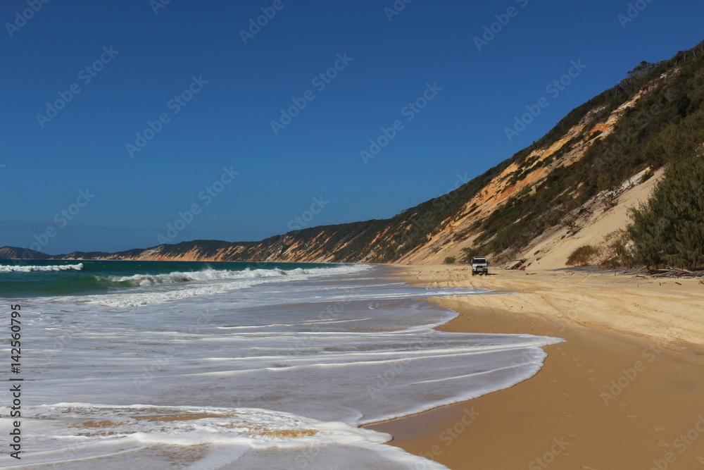 Driving on the beach when the tide begins to flood at Rainbow Beach, Queensland, Australia