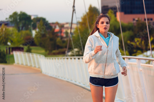 Sporty woman running at sunset in sunny park © guerrieroale