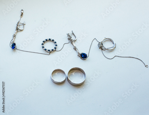 The wedding rings ,earrings and necklace stand on the table