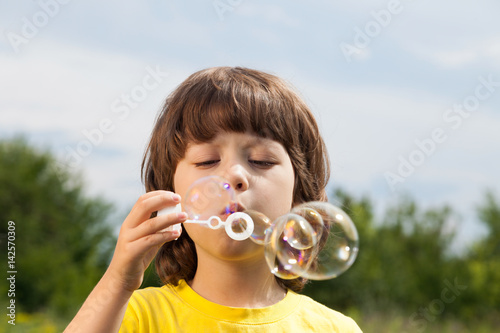 happy boy play in bubbles outdoors