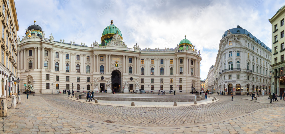 Fototapeta premium Cloudy panoramic view of Hofburg Palace at Michaelerplatz, Habsburg Empire landmark in Vienna, Austria.