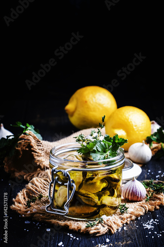 Mussels in olive oil with lemon and herbs, dark background, selective focus