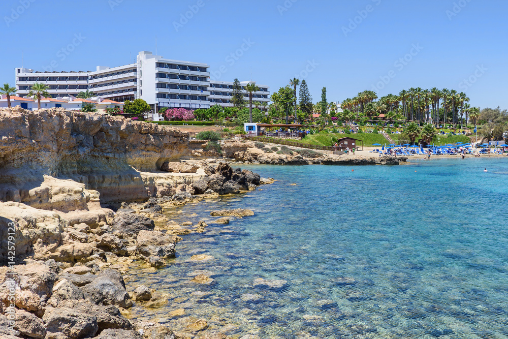 Fototapeta premium Hotel relaxing zone with palm trees and sea view in protaras, cyprus island, rocks and immaculate water
