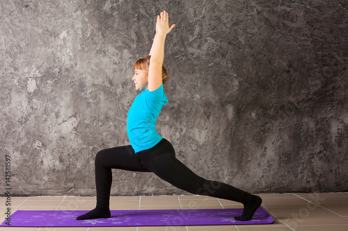 beautiful woman doing yoga on gray background
