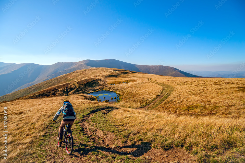 Mountain biker riding the bike on the trail to horizon line.  Extreme sport concept.