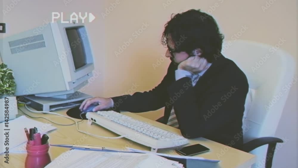 Fake VHS tape: a male employee at work in the office is annoyed and depressed. He gets mad at his pc, then turns off the monitor and leaves.
