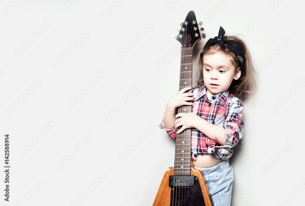 Beautiful artistic little girl playing guitar on grey background. Place for your text Beautiful artistic little girl playing guitar on grey background. Place for your text