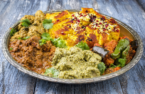 Traditional Indian Iranian Curries as close-up on a Thali photo