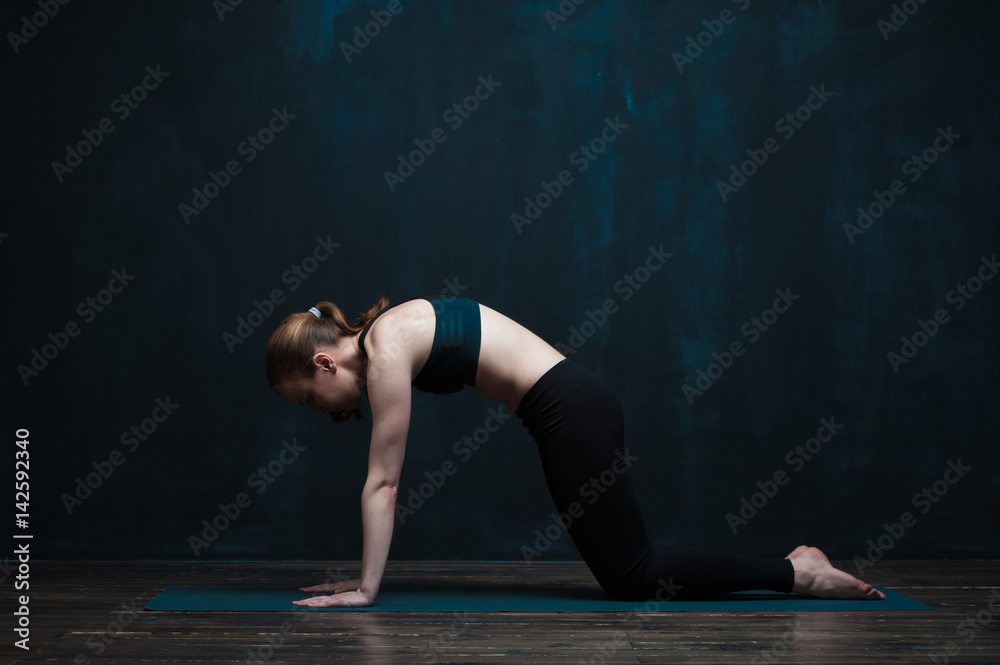 Sporty woman doing body balance exercises on mat