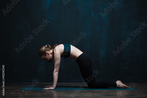 Sporty woman doing body balance exercises on mat