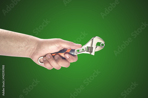 Man's hand holding big wrench