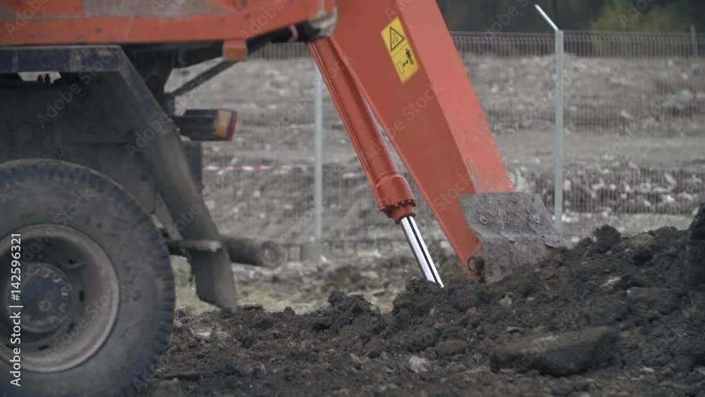 Excavator transports ground.Soil falling out of scoop. Construction excavator digging in the ground at construction or job site. Slow motion shot.Heavy machinery,industrial equipment concept. Excavator transports ground.Soil falling out of scoop. Construction excavator digging in the ground at construction or job site. Slow motion shot.Heavy machinery,industrial equipment concept.