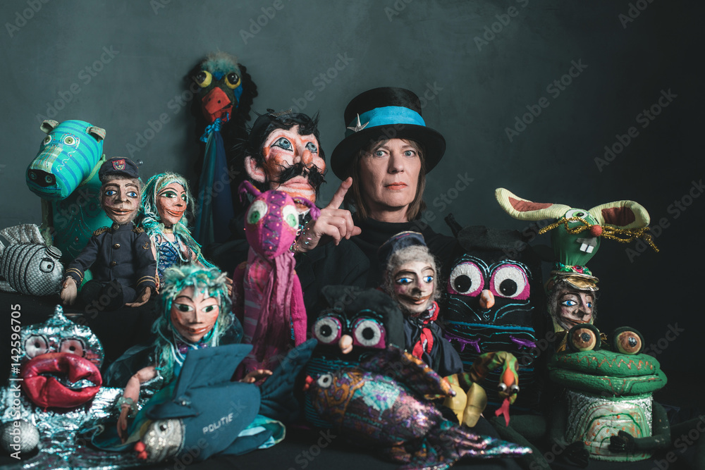 Puppeteer standing between handmade puppets.