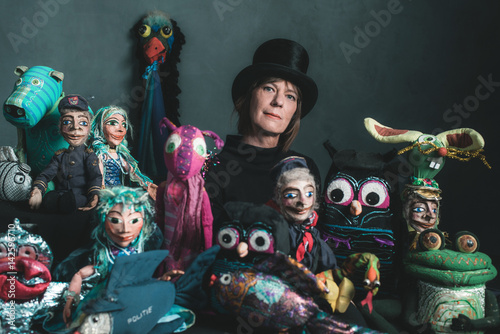 Puppeteer standing between handmade puppets.