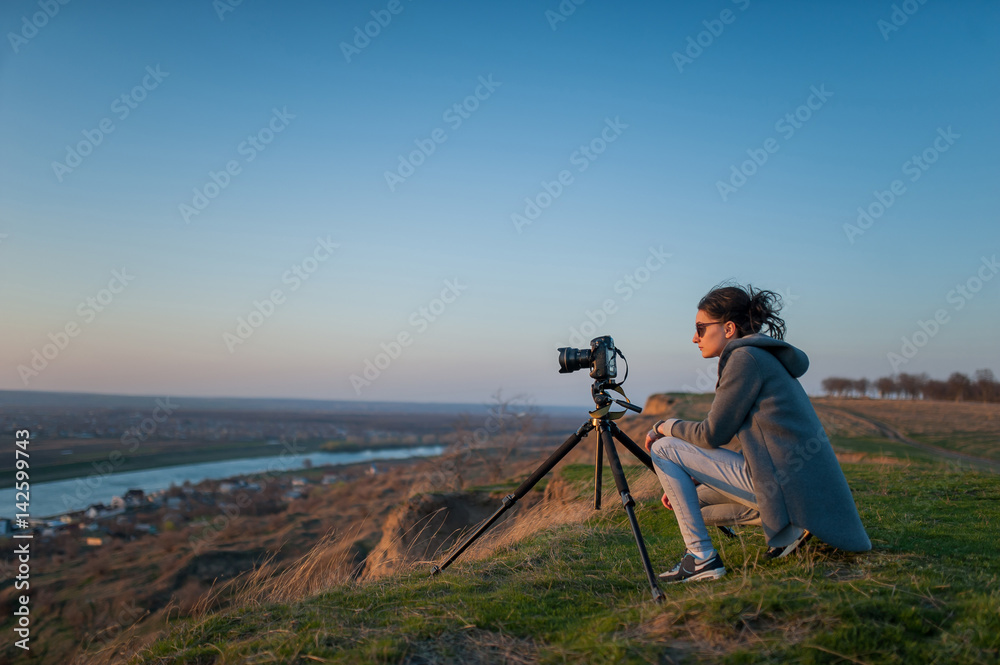 A tripod with a camera shoots the landscape