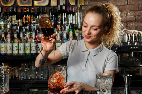 Woman bartender making an alcohol cocktail