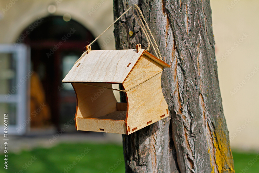 Empty wooden bird feeder hanging on a tree Empty wooden bird feeder hanging on a tree