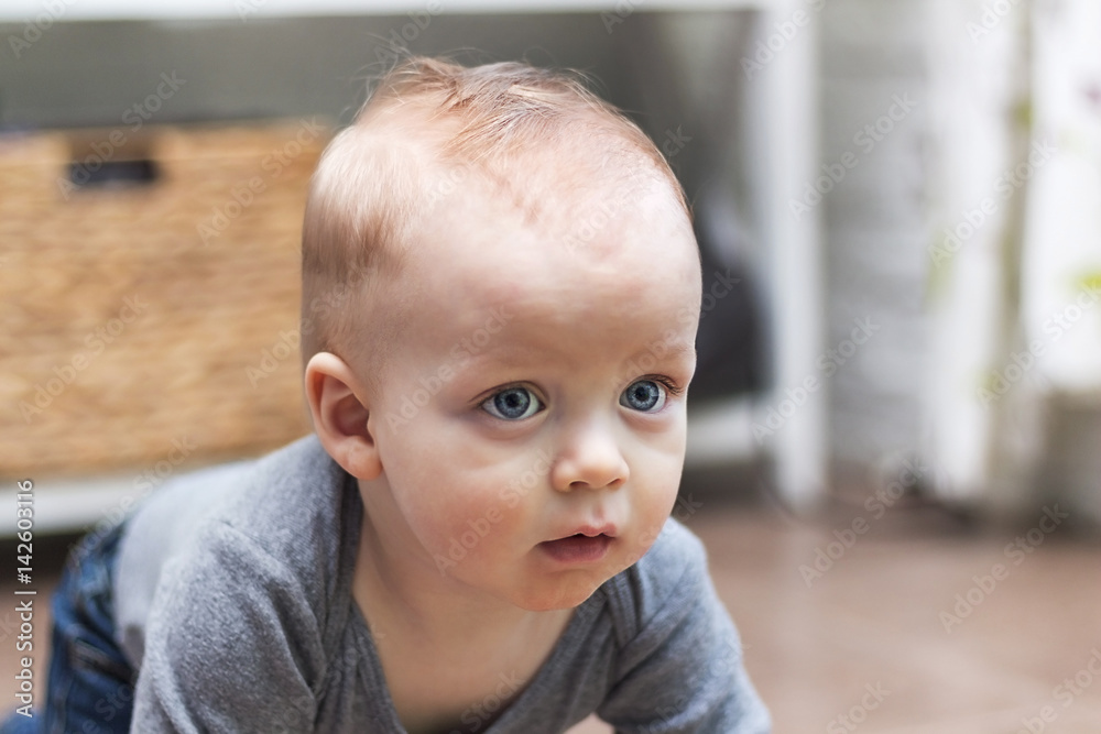 Serious one-year-old toddler closeup portrait. Attractive sad blond little boy with beautiful blue eyes in his thoughts Serious one-year-old toddler closeup portrait. Attractive sad blond little boy with beautiful blue eyes in his thoughts