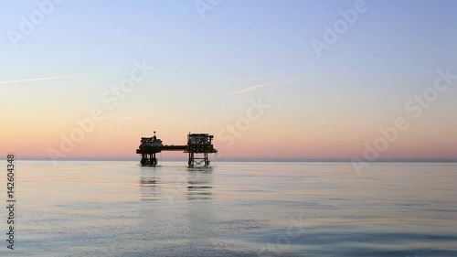 Silhouette of offshore oil platform at sunset