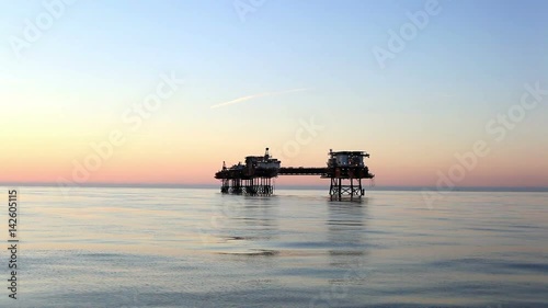 Silhouette of offshore oil platform at sunset