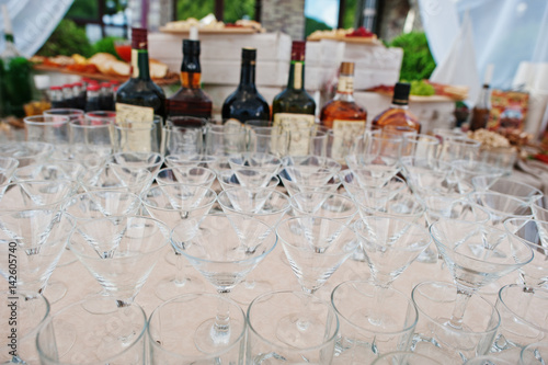 Different alcohol glasses at wedding catering table.