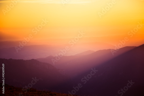 A beautiful, colorful, abstract mountain landscape in a mystic purple and orange tonality. Decorative, artistic look.