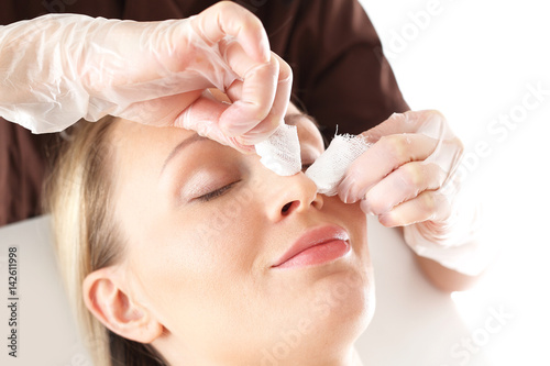 
Oczyszczanie skóry twarzy, kosmetyczka wyciska zaskórniki.