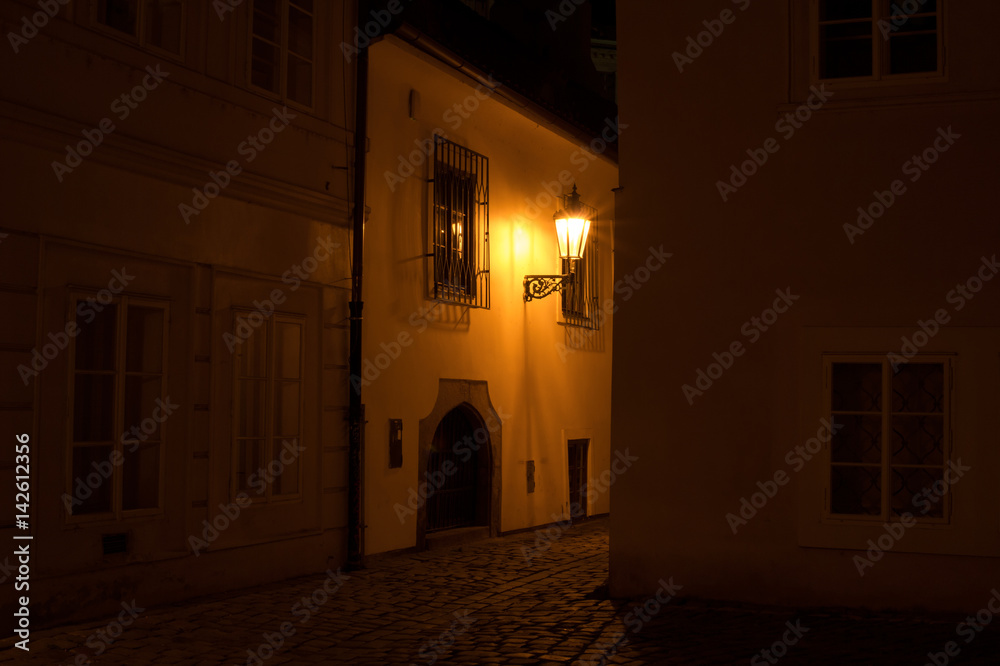 Old Town, Prague, Czech Republic / Czechia, Europe - narrow street and old buildings at night are lit by light from lantern. Mysterious atmosphere