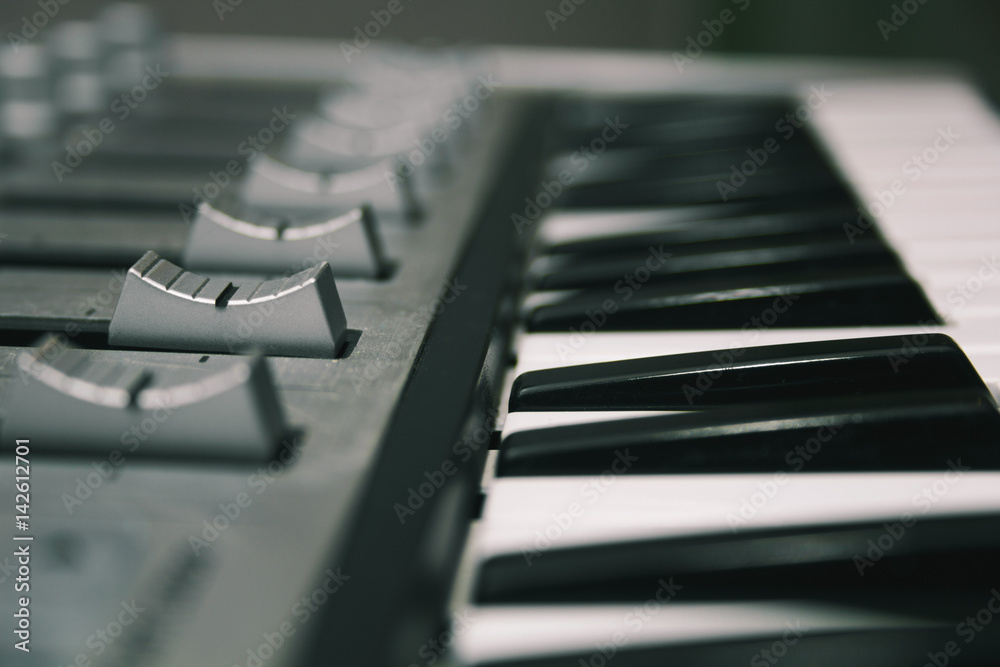 Midi keyboard close-up, keys and faders