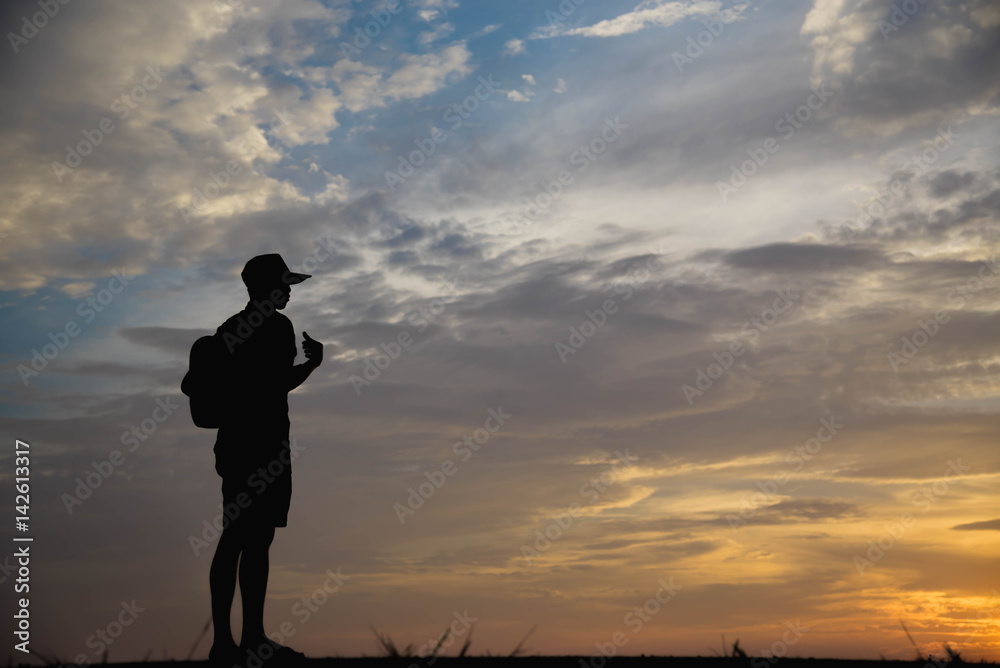 Fototapeta premium Silhouette of a man looking to sky at sunset.