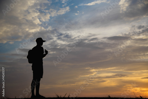 Silhouette of a man looking to sky at sunset.