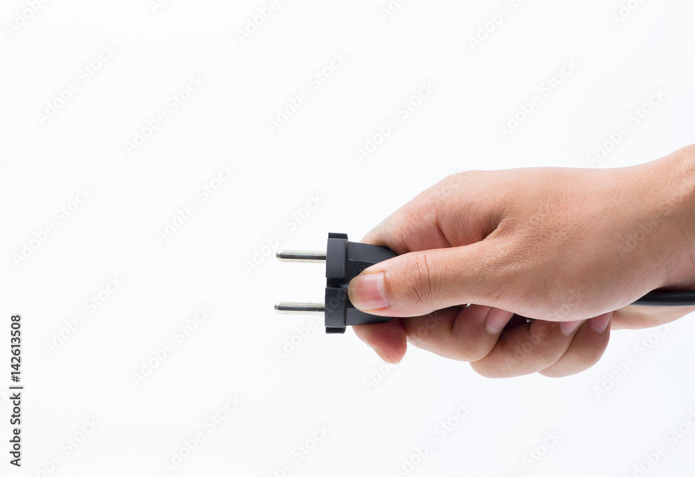 Hand inserting green electrical plug into outlet Hand inserting green electrical plug into outlet