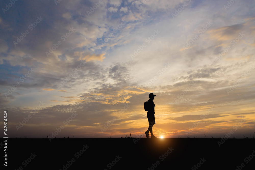 Silhouette of a man happy walking at sunset.