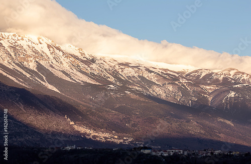 mountain side with snow on the top and Roccacasale village in the back