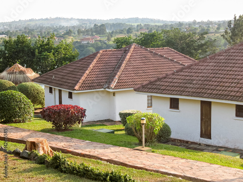 Cottages with lawn and decorative plants before. Jinja, Uganda, Eastern Africa.
