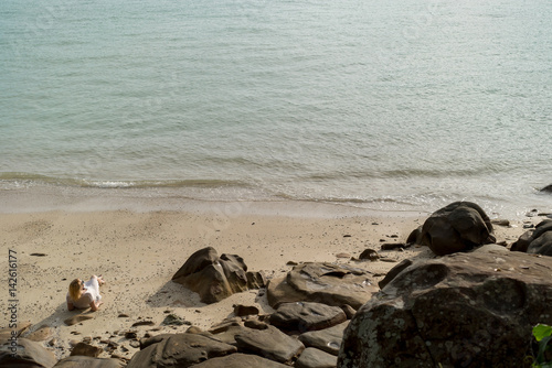 Young blonde woman on a beach in beach dress